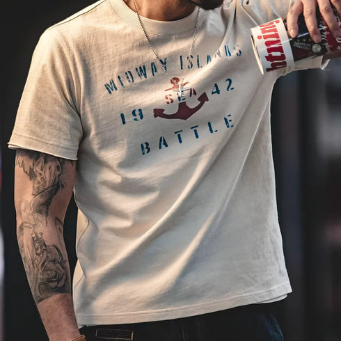 Person wearing a t-shirt with 'Midway Islands 1942 Battle' design, holding a can.